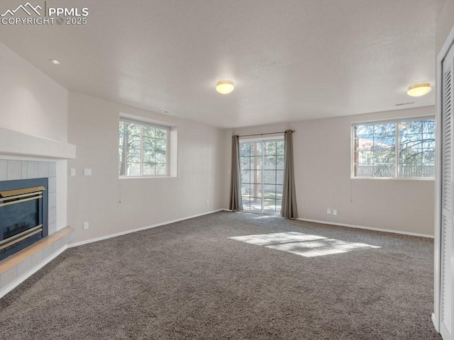 unfurnished living room featuring a tile fireplace and carpet floors