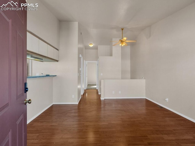 spare room featuring high vaulted ceiling, dark wood-type flooring, and ceiling fan