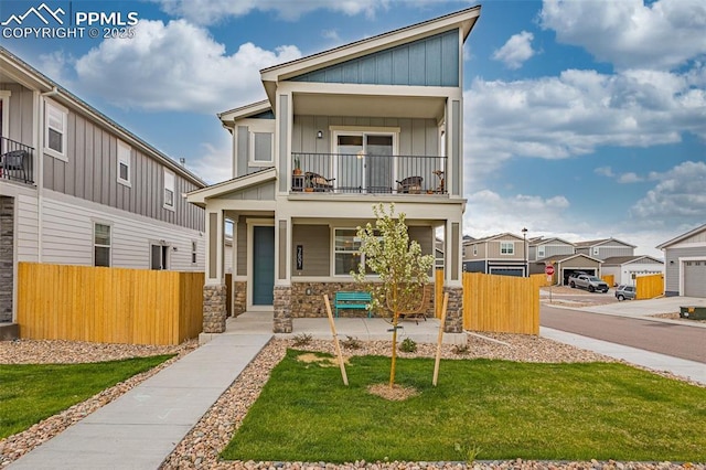 view of front facade featuring a balcony, covered porch, and a front lawn