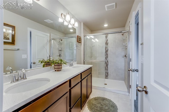 bathroom featuring vanity, a shower with shower door, and tile patterned flooring