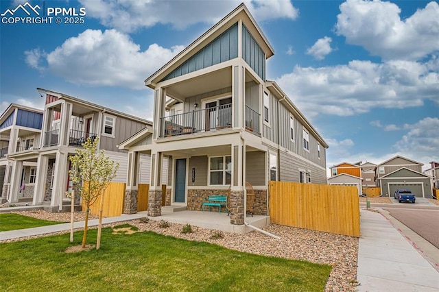 view of front of house with a balcony, covered porch, and a front lawn