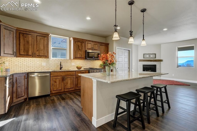 kitchen featuring a kitchen bar, sink, a center island, and appliances with stainless steel finishes