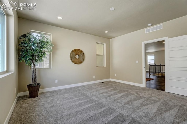 spare room with dark colored carpet