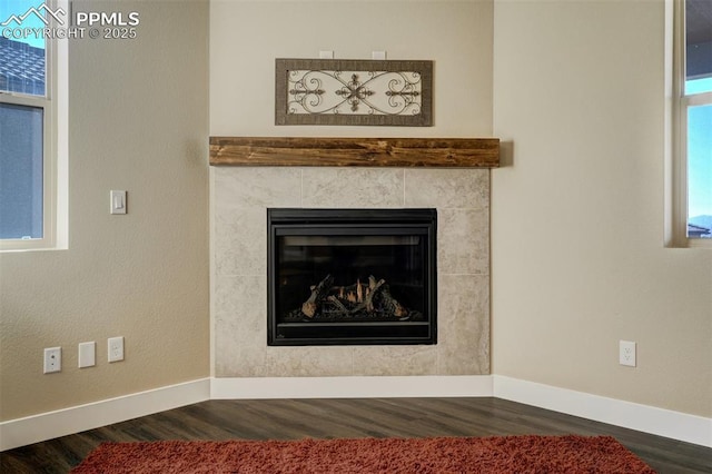 room details featuring wood-type flooring and a tile fireplace