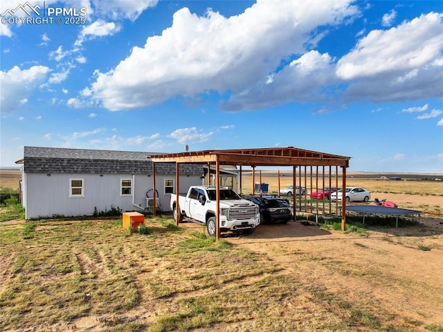 view of parking featuring a carport and a trampoline