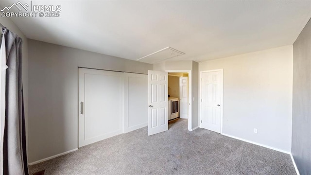 unfurnished bedroom with washer / dryer and carpet flooring