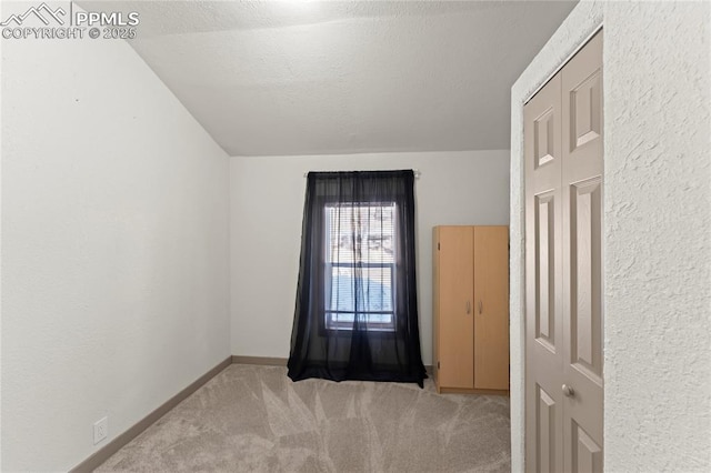 spare room featuring light carpet and a textured ceiling