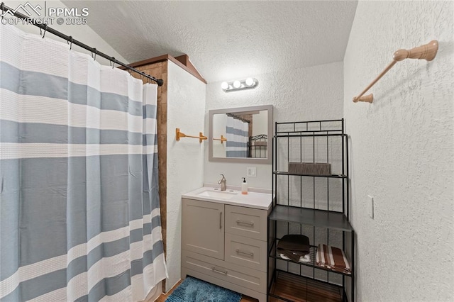 bathroom with lofted ceiling, vanity, curtained shower, and a textured ceiling