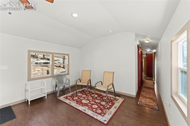 sitting room with vaulted ceiling and dark wood-type flooring