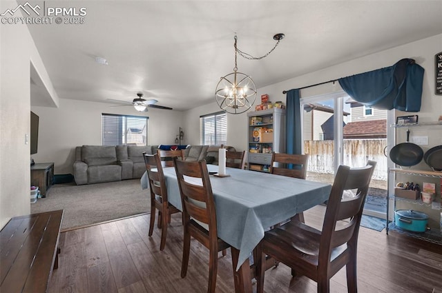 dining room with dark hardwood / wood-style floors and ceiling fan with notable chandelier