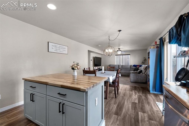 kitchen featuring an inviting chandelier, wooden counters, decorative light fixtures, dark hardwood / wood-style floors, and gray cabinets