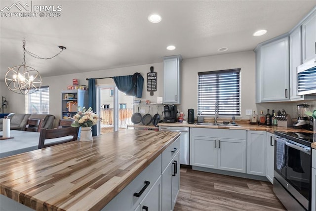 kitchen featuring stainless steel appliances, white cabinets, and wood counters