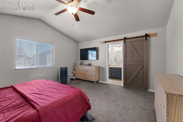 bedroom with lofted ceiling, light colored carpet, ceiling fan, a barn door, and ensuite bath