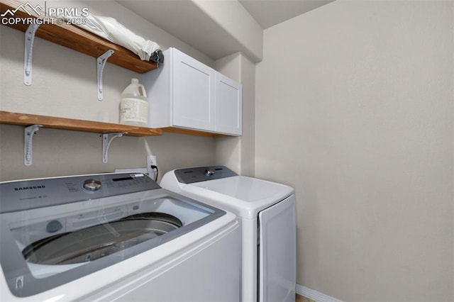 washroom featuring washing machine and dryer and cabinets