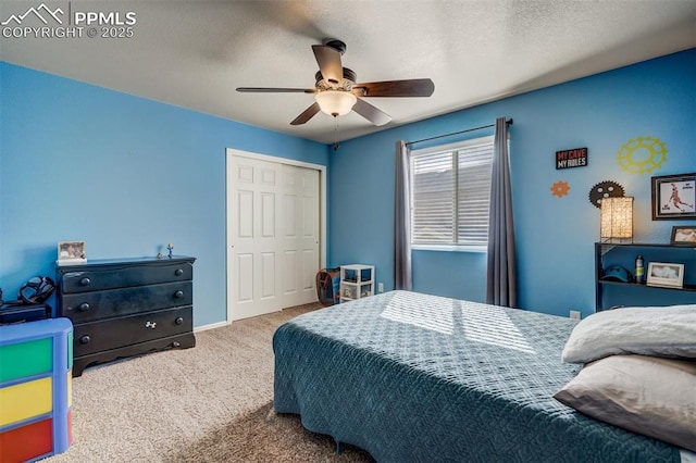 carpeted bedroom featuring ceiling fan, a closet, and a textured ceiling