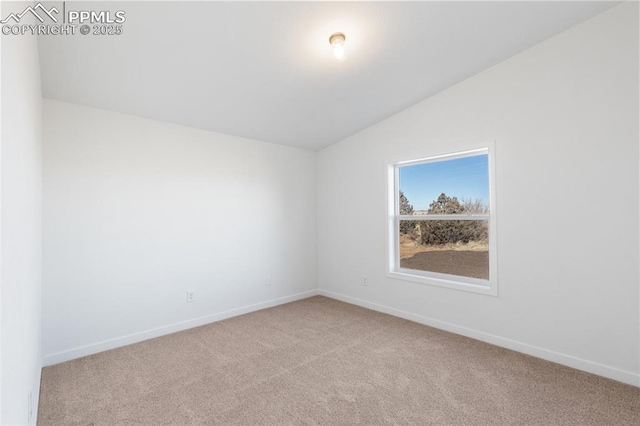 spare room featuring light carpet and vaulted ceiling