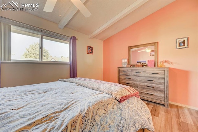 bedroom with ceiling fan, lofted ceiling with beams, and light wood-type flooring