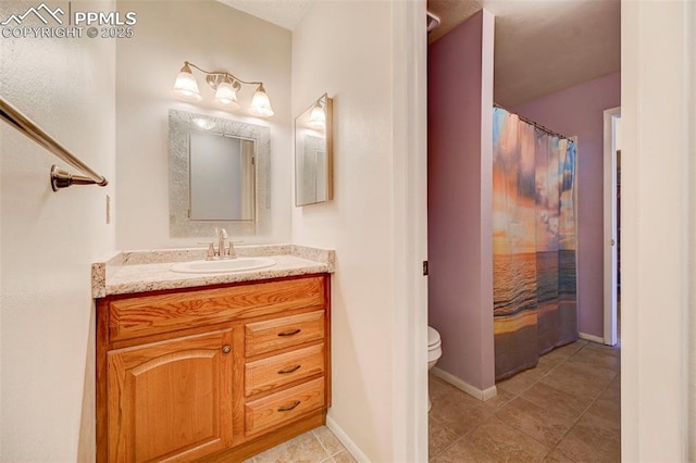 bathroom featuring vanity, tile patterned floors, and toilet