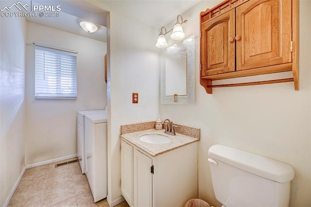 bathroom with vanity, tile patterned flooring, washer and dryer, and toilet