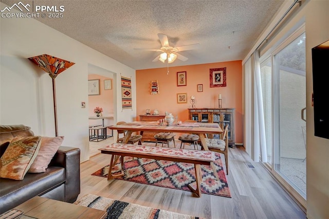 dining space featuring a textured ceiling, ceiling fan, and light hardwood / wood-style flooring