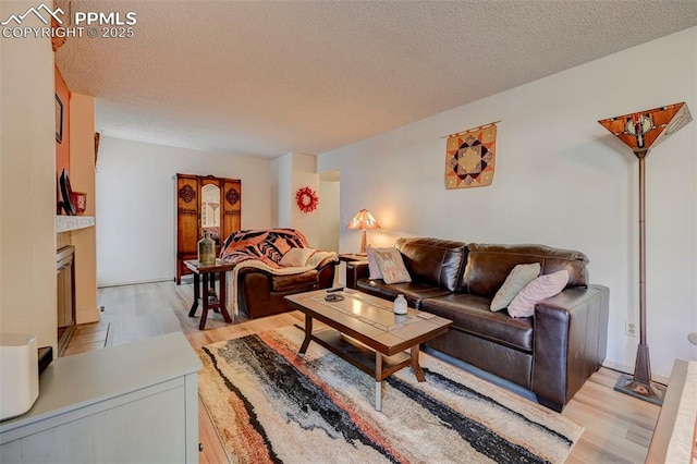 living room with light hardwood / wood-style flooring and a textured ceiling