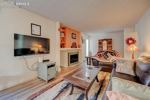 living room with light hardwood / wood-style floors and a textured ceiling