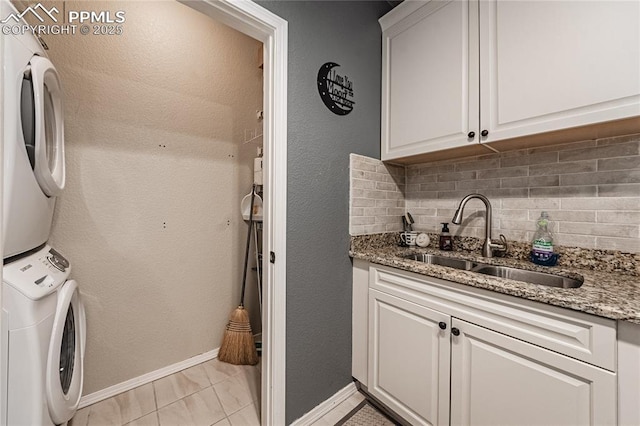 laundry room with cabinets, stacked washer / drying machine, indoor wet bar, and light tile patterned floors