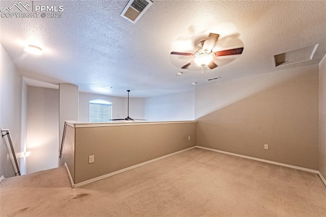 carpeted spare room featuring a textured ceiling and ceiling fan