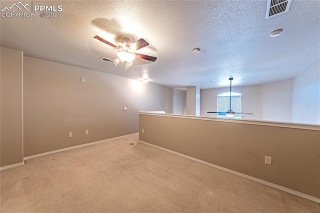 empty room featuring ceiling fan, carpet flooring, and a textured ceiling