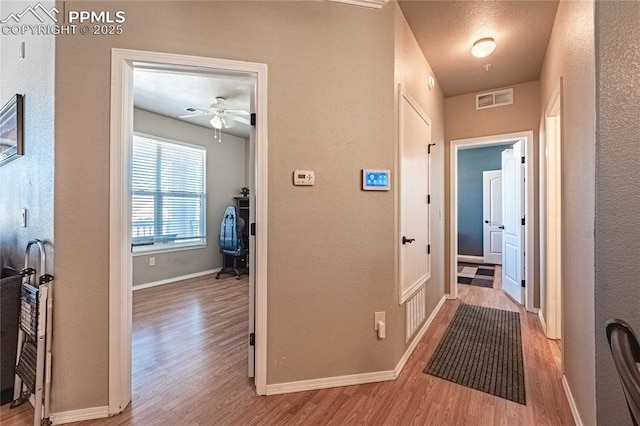 corridor with light hardwood / wood-style floors