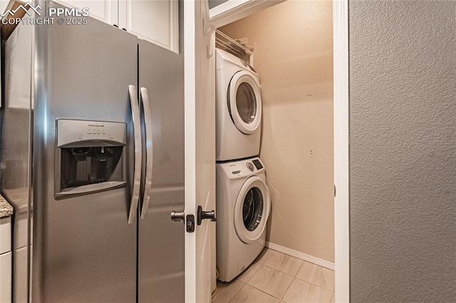 washroom with light tile patterned flooring and stacked washer / dryer