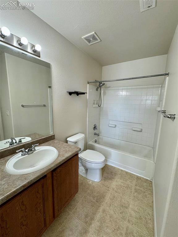 full bath with washtub / shower combination, visible vents, toilet, and vanity