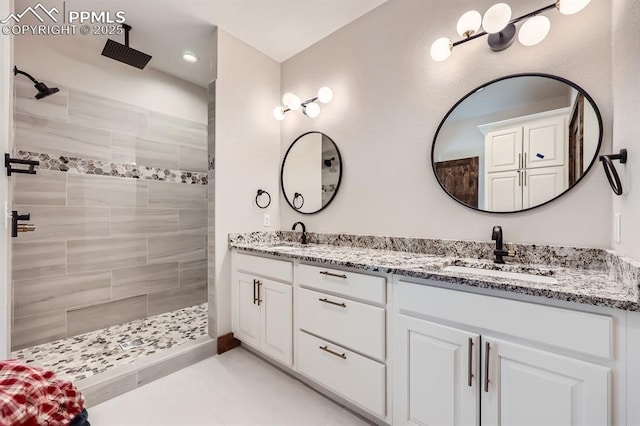 bathroom featuring tiled shower and vanity