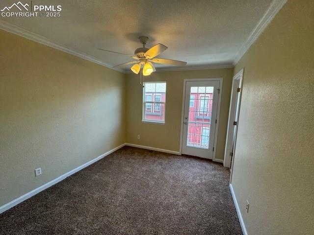 unfurnished room featuring dark carpet, crown molding, and ceiling fan