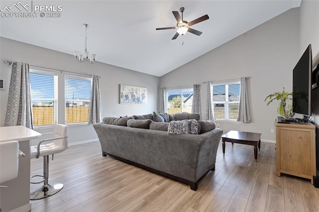 living room featuring ceiling fan with notable chandelier, light hardwood / wood-style flooring, and high vaulted ceiling