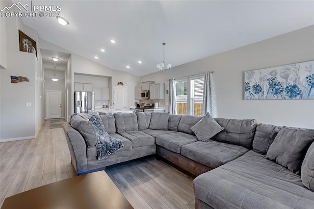 living room featuring high vaulted ceiling, sink, an inviting chandelier, and light wood-type flooring