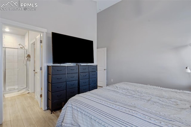 bedroom featuring a towering ceiling and light hardwood / wood-style flooring