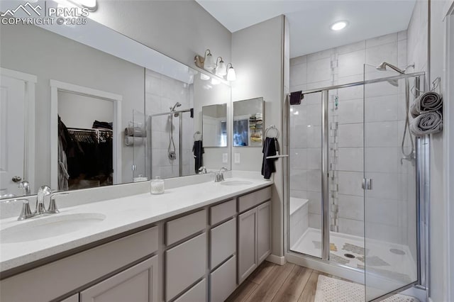 bathroom featuring an enclosed shower, vanity, and wood-type flooring