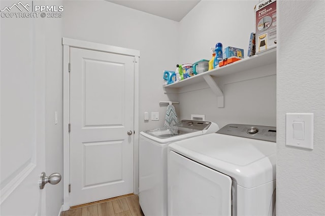 washroom with light hardwood / wood-style flooring and washing machine and clothes dryer