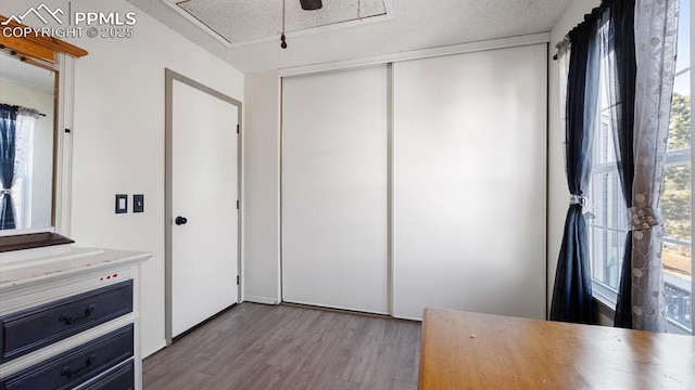 interior space with a textured ceiling, light wood-type flooring, and a closet