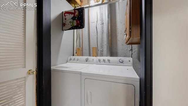 washroom featuring separate washer and dryer and cabinets