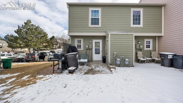 view of snow covered back of property