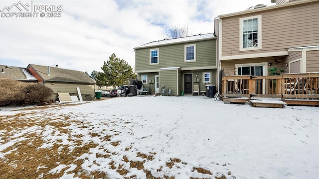 snow covered rear of property featuring a wooden deck