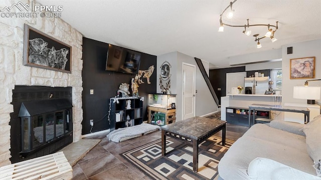 living room featuring a stone fireplace and tile patterned flooring