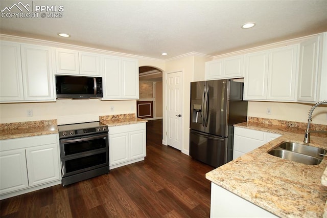 kitchen with appliances with stainless steel finishes, dark hardwood / wood-style floors, white cabinetry, sink, and light stone counters