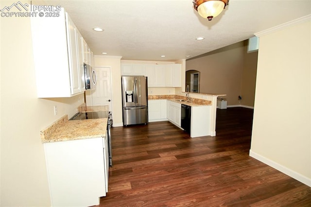 kitchen featuring appliances with stainless steel finishes, white cabinetry, sink, dark hardwood / wood-style flooring, and kitchen peninsula