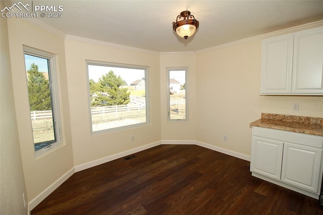 unfurnished dining area with ornamental molding and dark hardwood / wood-style flooring