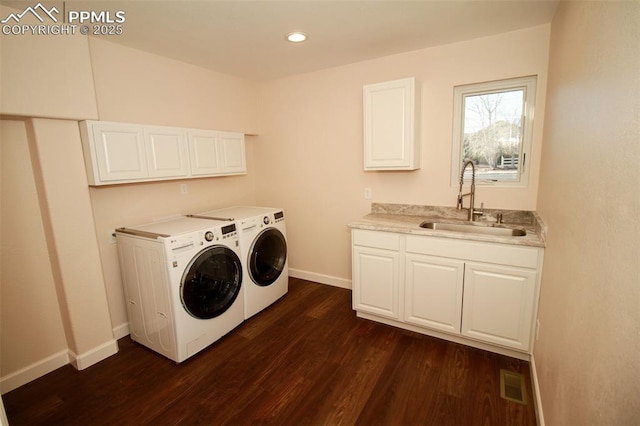 washroom featuring cabinets, sink, dark wood-type flooring, and independent washer and dryer