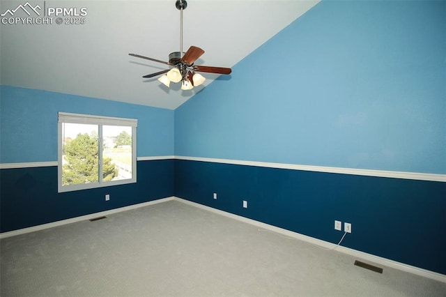 carpeted empty room featuring ceiling fan and vaulted ceiling