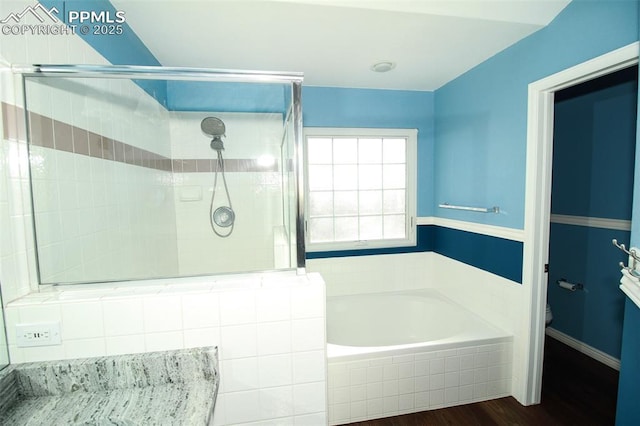 bathroom featuring hardwood / wood-style flooring, shower with separate bathtub, and toilet